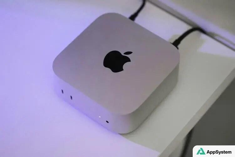 Mac mini Apple posé sur un bureau avec éclairage violet