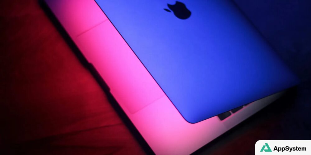 Ordinateur portable Apple éclairé par des lumières bleue et rose