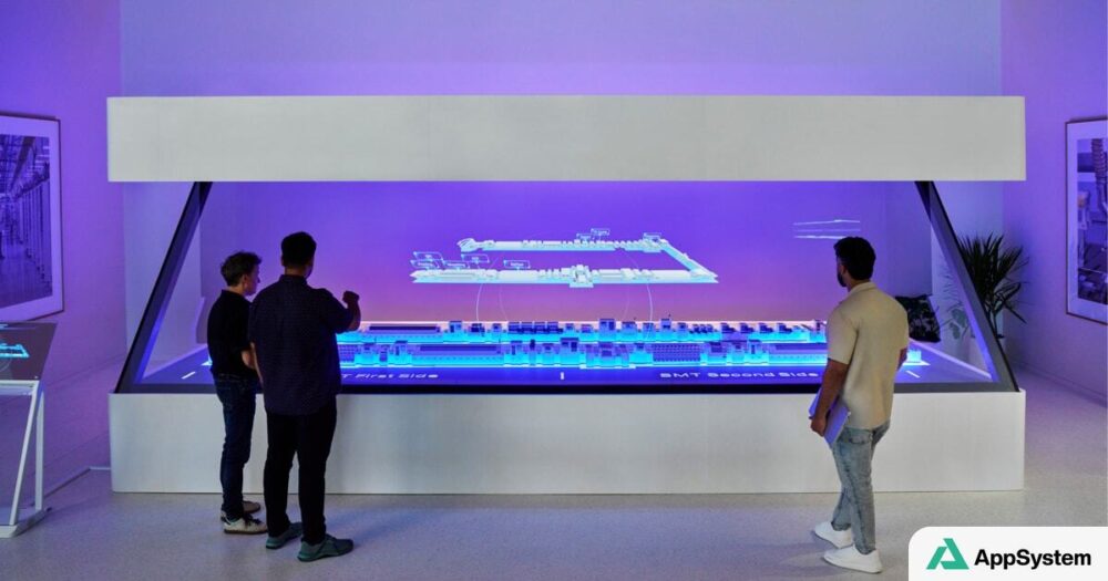 Visiteurs observent une maquette numérique du centre de fabrication Apple