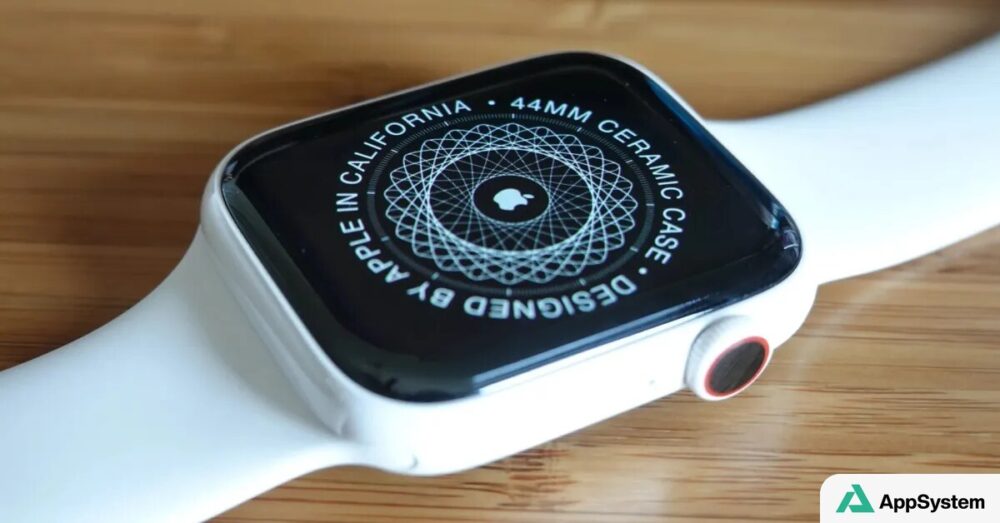 Apple Watch blanche avec boîtier en céramique sur une table en bois