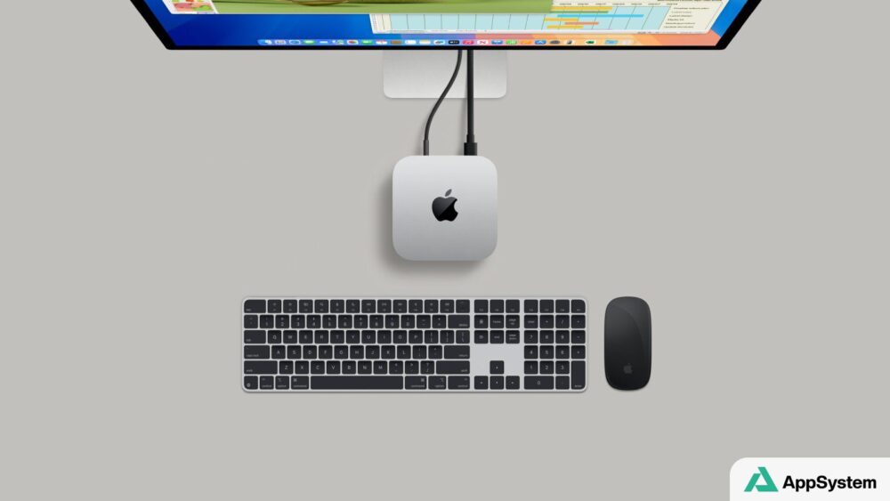 Mac mini Apple installé sous un écran avec clavier et souris