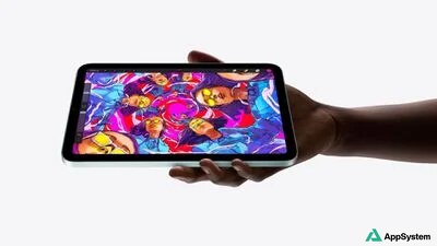 iPad mini tenu horizontalement, affichant une illustration colorée