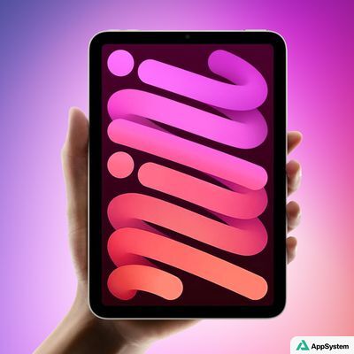 iPad tenu à la main devant un fond coloré