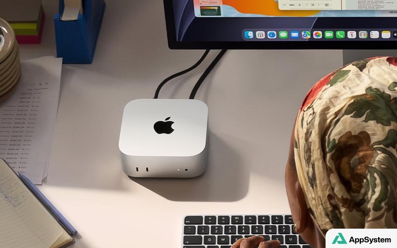 Mac mini posé sur un bureau devant un écran
