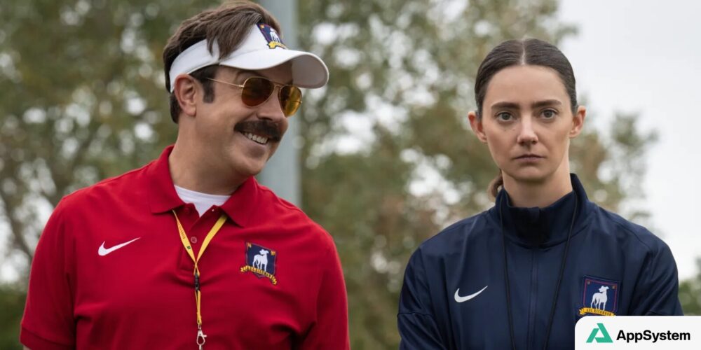 Ted Lasso et une entraîneuse posent côte à côte