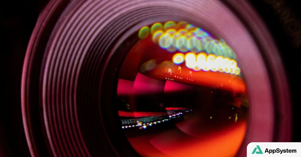 Gros plan sur un objectif photo aux reflets lumineux colorés.