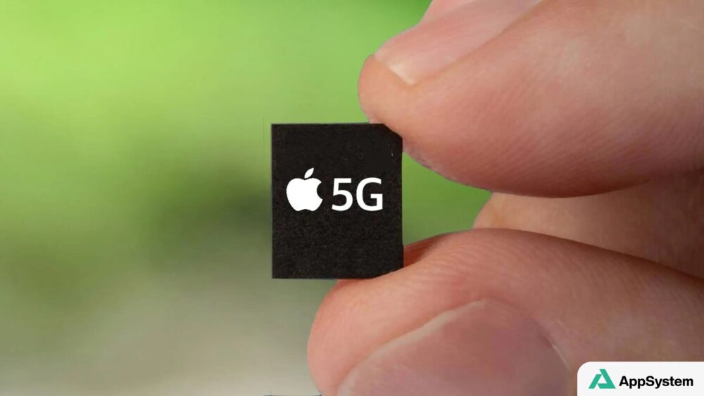 Puce Apple 5G tenue entre les doigts, illustrant le modem iPhone