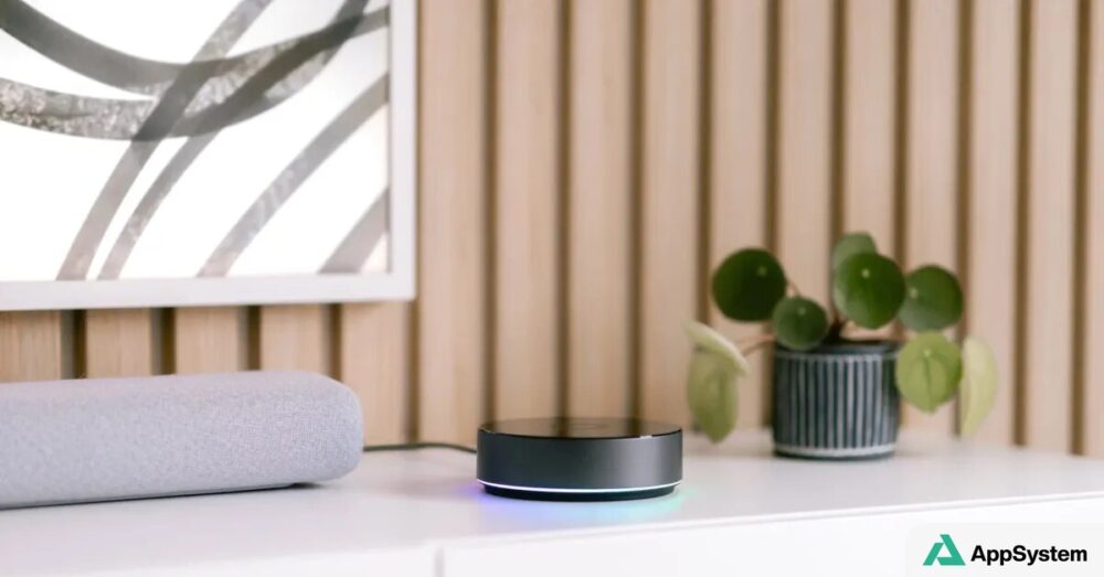 Enceinte connectée et boîtier domotique posés sur un meuble