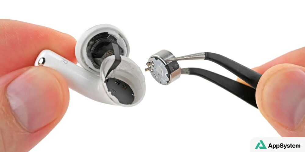 Écouteur AirPods 5 ouvert pendant l’extraction d’un composant interne