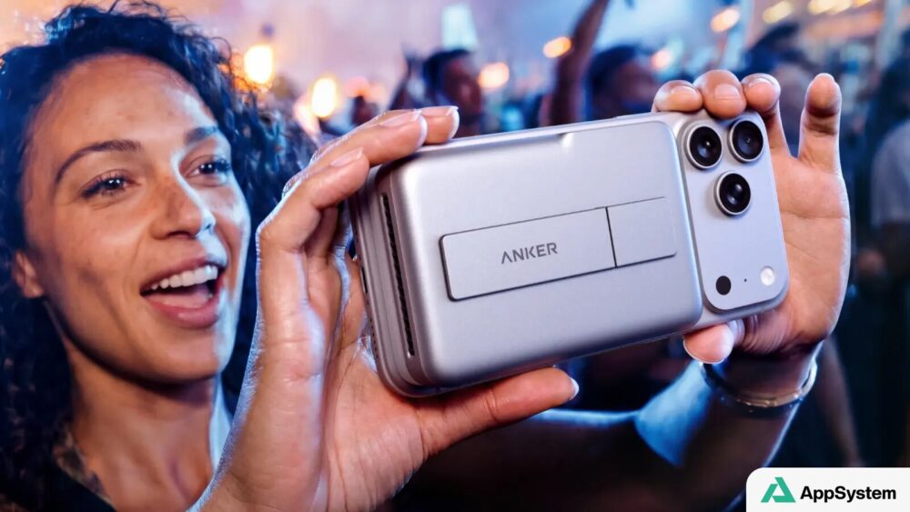Une personne présente un chargeur Anker fixé derrière un smartphone