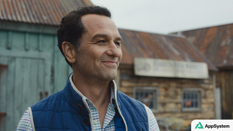 Un homme souriant devant des bâtiments anciens