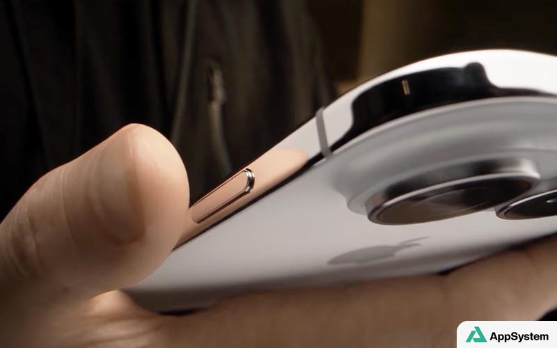 Gros plan sur le bouton latéral d’un iPhone tenu en main