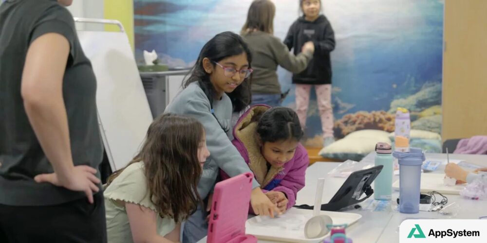 Des enfants collaborent autour de tablettes dans une classe