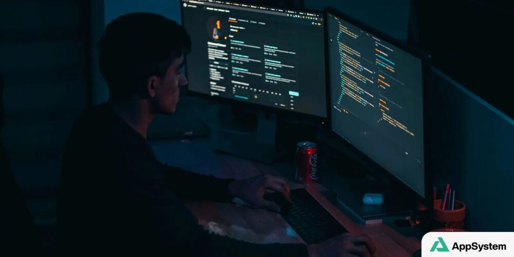 Personne travaillant sur du code informatique à plusieurs écrans