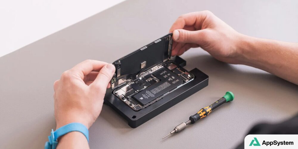 Technicien ouvrant un iPhone pour remplacer ses composants internes