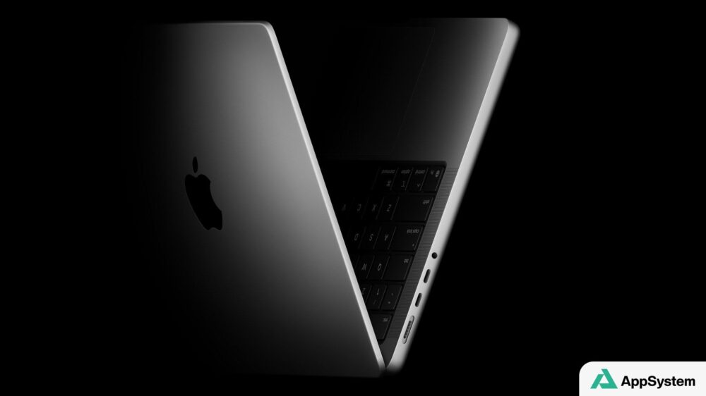 MacBook ouvert vu de dos, présentant son clavier et ses ports latéraux.
