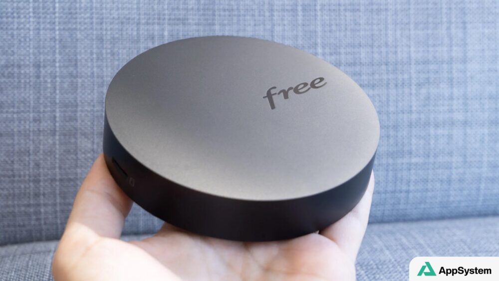 Décodeur Freebox rond tenu dans une main