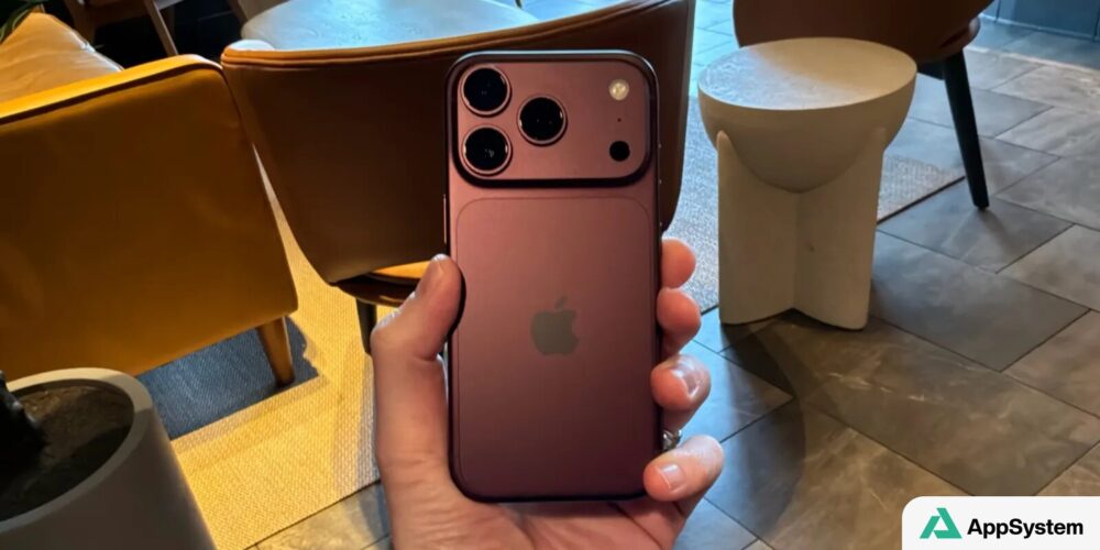 iPhone rose présenté au dos, avec trois objectifs photographiques