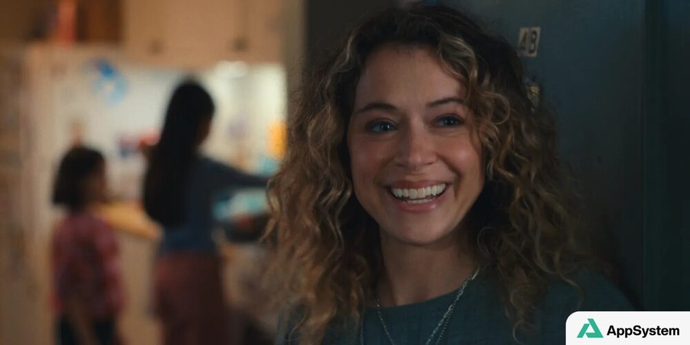 Femme souriante aux cheveux bouclés, dans une scène intérieure