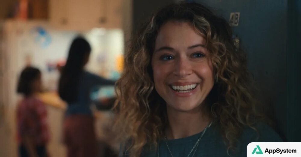 Personnage féminin souriant dans un intérieur, scène de la série