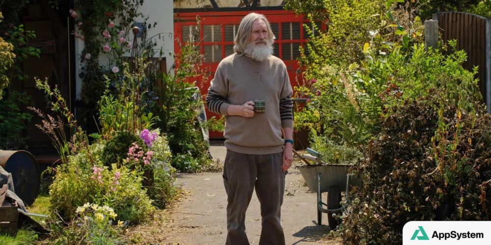 Homme barbu tenant une tasse dans un jardin fleuri