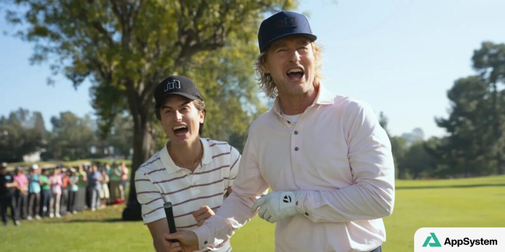 Deux hommes sourient sur un parcours de golf devant des spectateurs