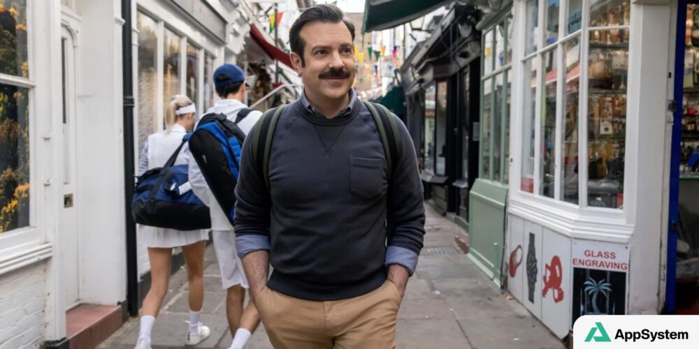 Ted Lasso déambule dans une rue londonienne avec son sac à dos