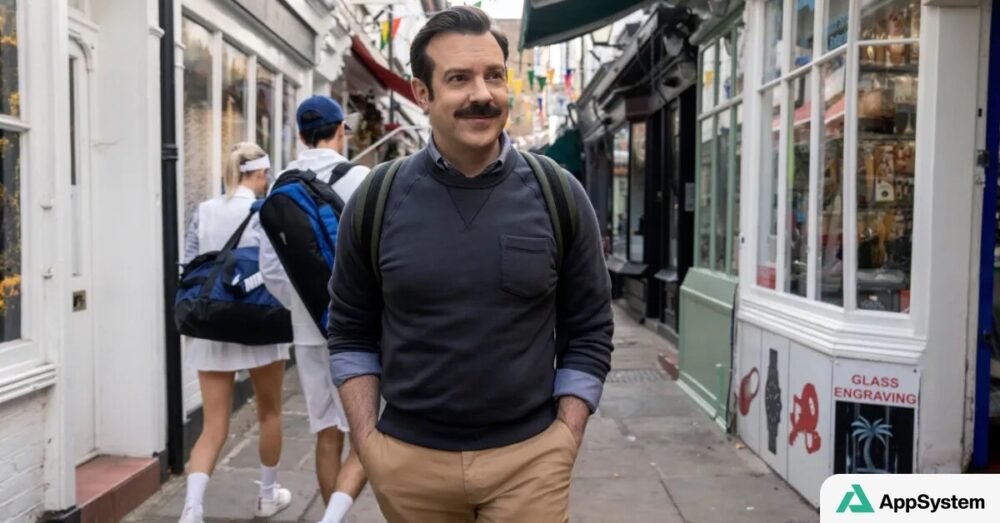 Ted Lasso marche dans une rue londonienne avec son sac à dos